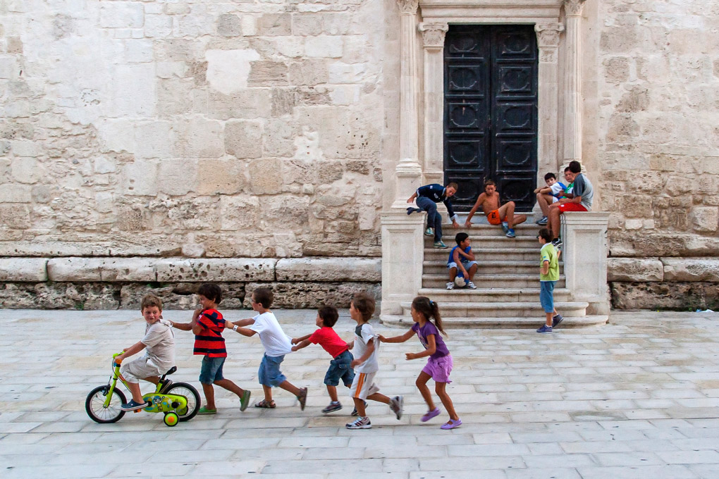 The Train of Joy, Syracuse, Sicily, Italy, children, play, game, train, human train, child train, bicycle, church, tradition, innocence, street photography, italian, style, street photography, happiness, happy kids, happy children, Mercedes Noriega, Mercedes Noriega Photography